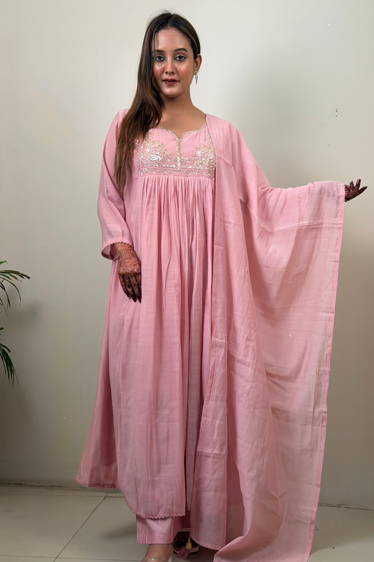 Woman wearing a pink traditional outfit with a plain background