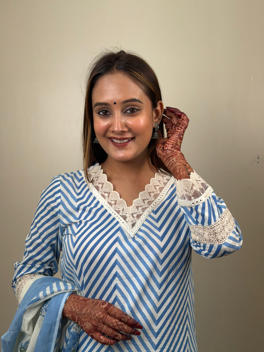 Woman wearing a blue and white striped kurta with lace details, posing against a plain background.