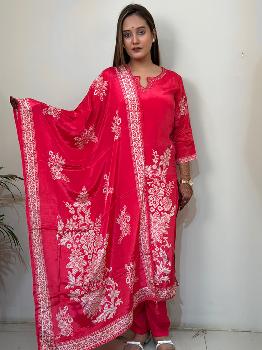 Woman wearing a red traditional outfit with white embroidery against a plain background