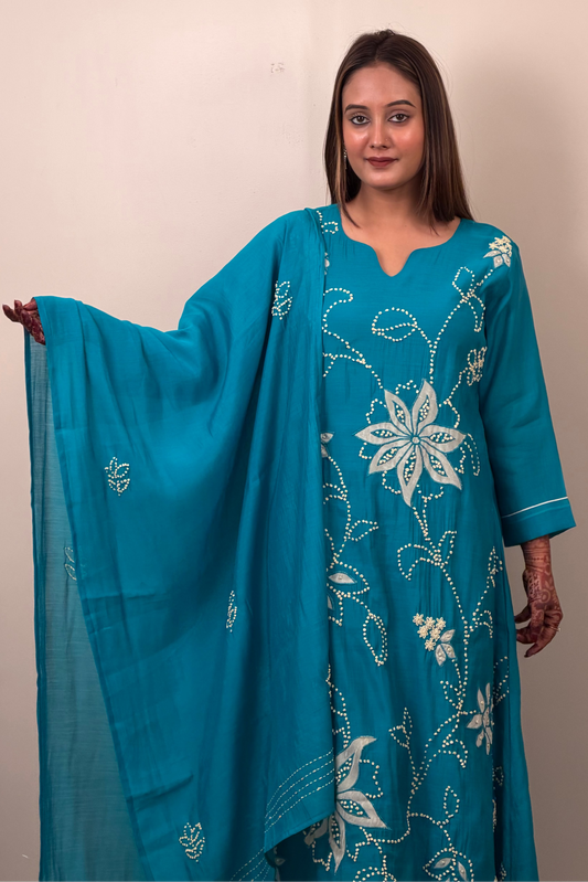 Woman holding a blue embroidered dupatta against a beige background
