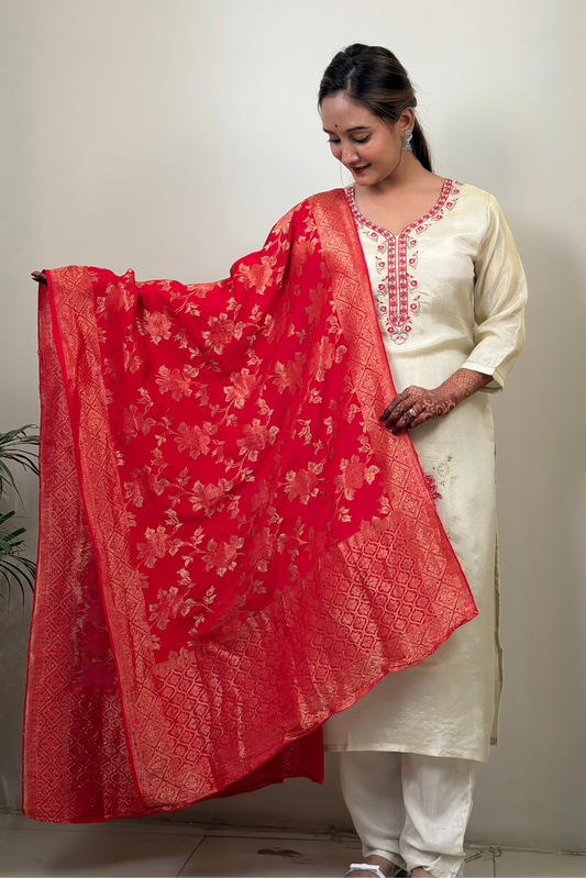 Woman holding a red floral dupatta with a plain background