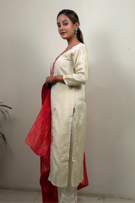 Woman wearing a cream kurta with a red dupatta against a plain background
