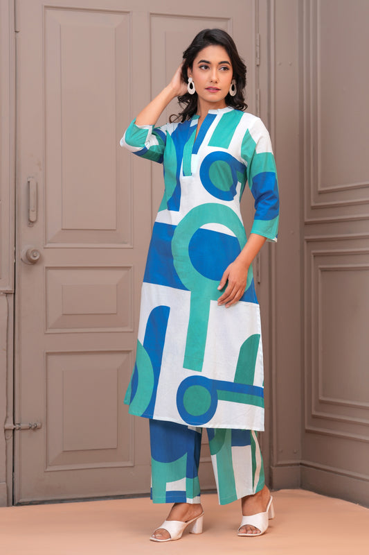 Woman wearing a blue and green patterned outfit against a neutral background